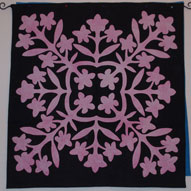 In Above the Rainbow, the quilt shop owner makes a quilt called "In the Black at the Pink Plumeria." After several quilt friends asked if I'd made the quilt described, I decided I should. This is the result, and this quilt was used as the basis for the cover design of St. Rose Goes Hawaiian.
